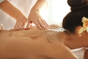 young woman receiving scrub massage spa salon